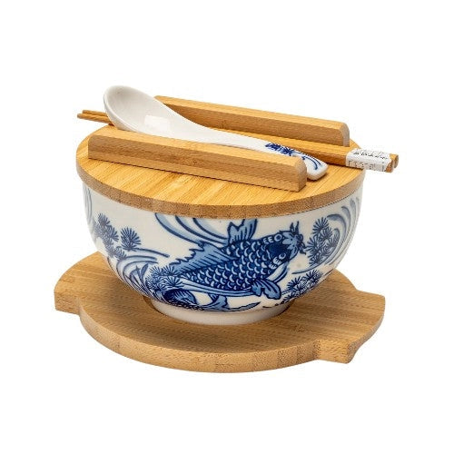 White and blue koi fish ceramic bowl with bamboo lid, trivet, wooden chopsticks, and porcelain spoon.