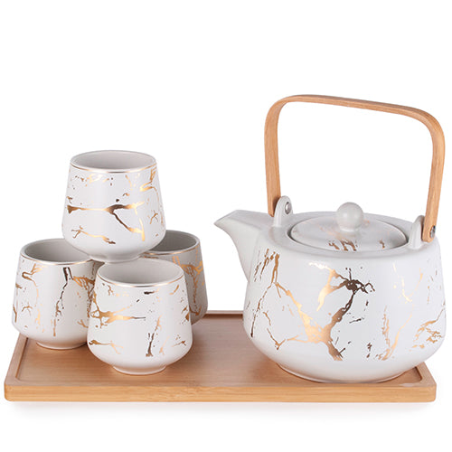 A ceramic tea set on a bamboo tray, featuring a teapot with a wooden bamboo handle and four cups, all with a white base and gold marbling design.