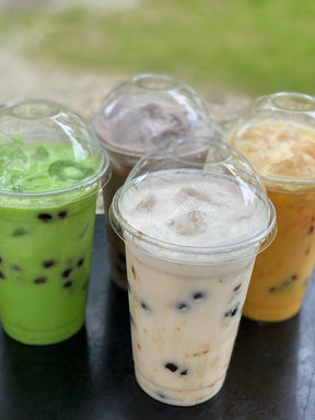 Assortment on bubble tea drinks in plastic cups with lids.
