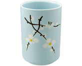 Taza de té azul con flores blancas