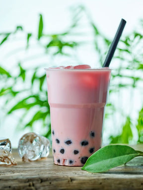 Strawberry Bubble Tea in a glass with straw and tapioca pearls.